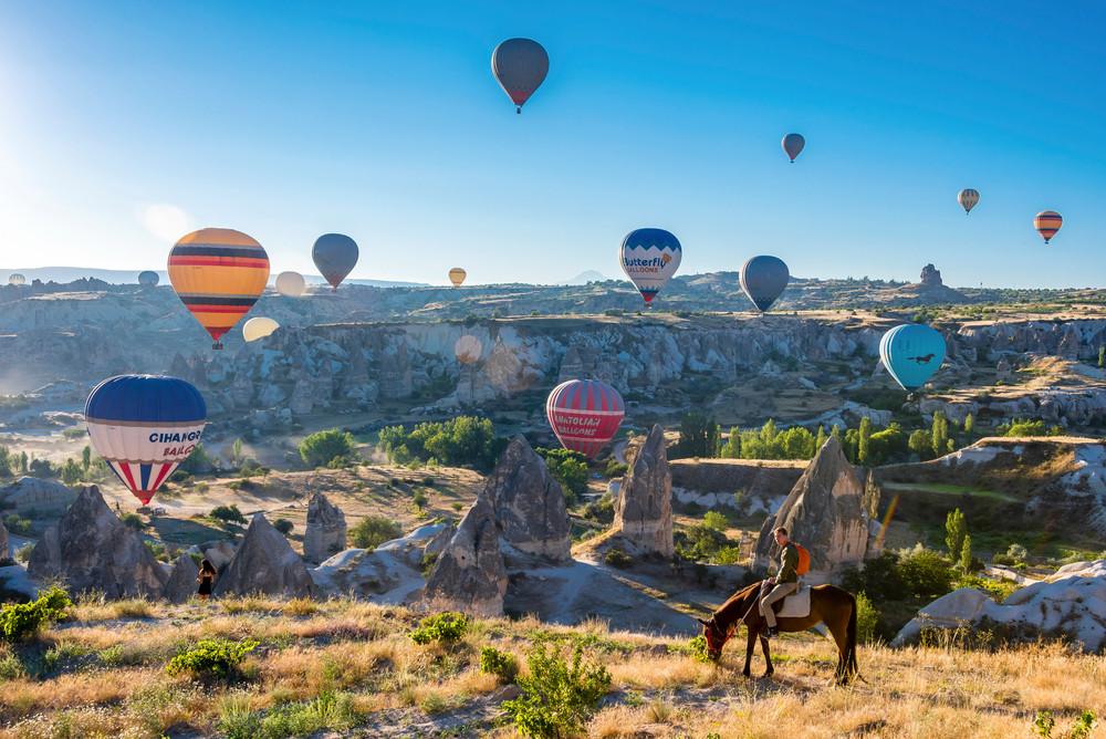 Horseback ride beneath hot air balloons, Cappadocia, Turkey. Nejdet Duzen / shutterstock.com