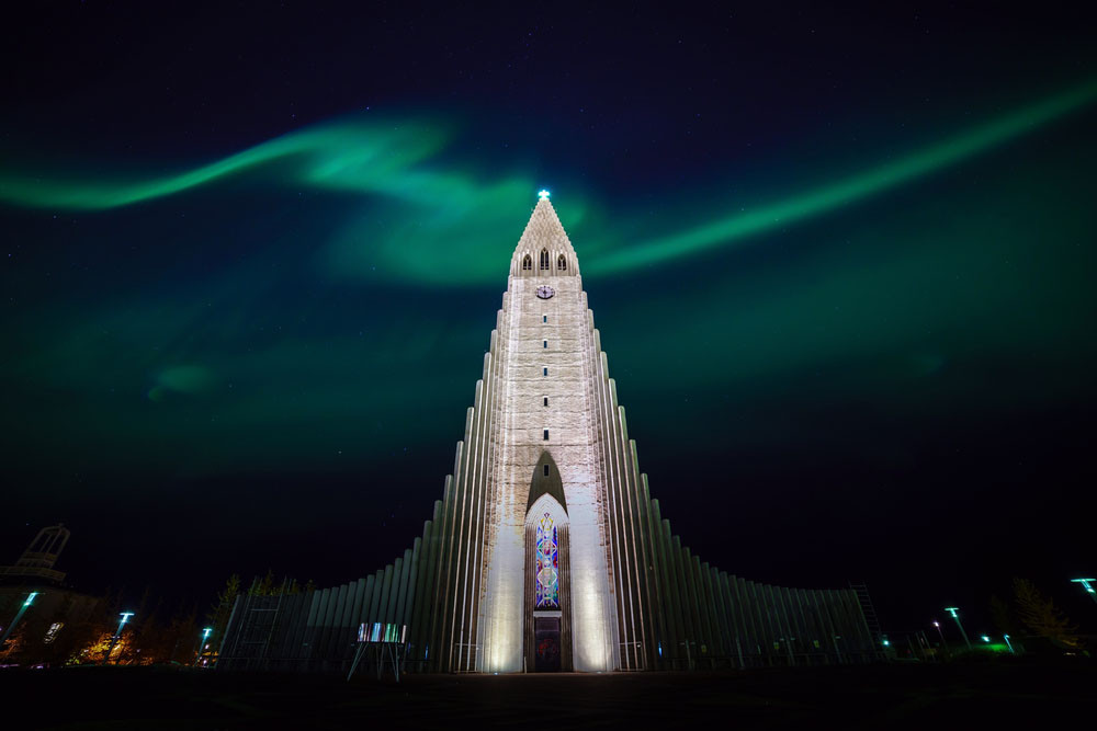 Colorful aurora borealis over the Hallgrímskirkja Church, Reyjavik, Iceland.